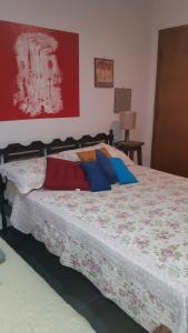 a bedroom with a bed with colorful pillows on it at B&B Sol Poente in Cunha