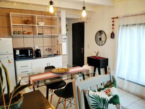a kitchen and dining room with a table and chairs at Casita de madera in Oberá