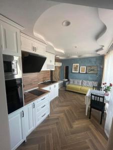 a large kitchen with white cabinets and a table at Petar Aparts in Balchik +21 photos