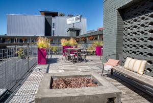 a patio with a fire pit and a table and chairs at The Grove West Seattle Inn in Seattle
