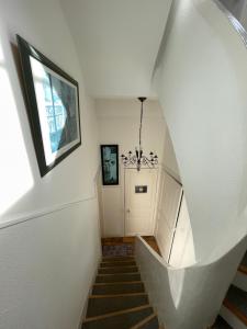 una escalera con una pared blanca y una puerta blanca en Le Grand Chalet, en Bagnoles de l'Orne