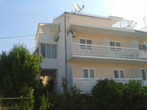 a large white building with a balcony at Apartments and Rooms Jasna in Hvar