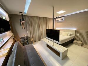 ein Wohnzimmer mit einem Sofa und einem Flachbild-TV in der Unterkunft Edifício Time Apto 916 ER Hospedagens in Maceió