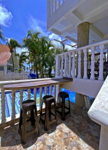 a balcony with stools next to a swimming pool at Sunset Paradise in San Andrés