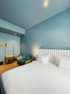 a bedroom with a large white bed and a blue wall at Esqina Cosmopolitan Lodge in Lisbon
