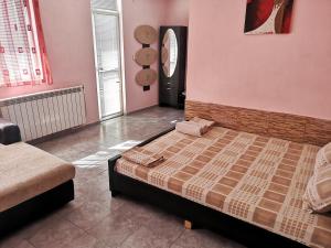ein Schlafzimmer mit einem Bett in einem Zimmer mit rosa Wänden in der Unterkunft Merilyn Petrich in Petrich