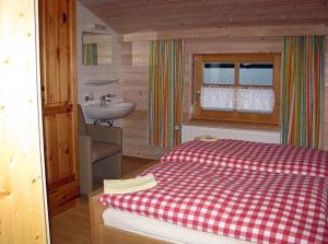 a bathroom with a bed and a sink in a room at Haus-Spannbauer-Wohnung-Dreisessel in Altreichenau