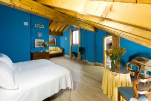 ein Schlafzimmer mit einem weißen Bett und blauen Wänden in der Unterkunft La Locanda Del Notaio in Pellio Inferiore