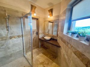 La salle de bains est pourvue d'une douche et d'un lavabo. dans l'établissement Noclegi - Karczma Solina, à Solina