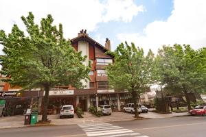 ein Gebäude auf einer Straße mit Bäumen davor in der Unterkunft Valle Dell Acqua in Gramado