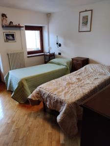 une chambre d'hôtel avec deux lits et une fenêtre dans l'établissement La vecchia scuola, à Saint Marcel