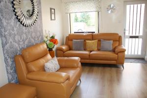 a living room with a leather couch and chairs at City Centre Town House with Riverside Views and Free Parking 1BAK in York