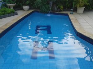 een zwembad met een reflectie van een persoon in het water bij Hotel Antonio's in Santa Cruz do Sul