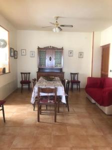 ein Wohnzimmer mit einem Tisch und einem roten Sofa in der Unterkunft CASALE MICHEL in Arpino