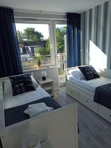 sypialnia z 2 łóżkami i dużym oknem w obiekcie Apartamenty Prima w Poddąbiu