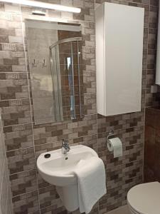 a bathroom with a white sink and a toilet at Apartamenty Prima in Poddąbie