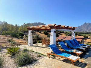 eine Gruppe von Liegestühlen unter einer Pergola in der Unterkunft Casa vacanza Lentisco D Sardegna Ogliastra in Tertenìa