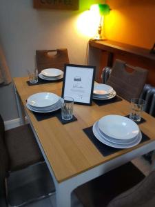 una mesa con platos y vasos y una tableta en ella en Magical 3-Bed Stone Built Cottage - Sleeps 6, en Ballynahinch