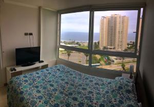 1 dormitorio con cama y ventana grande en Marina Horizonte II - Free Parking, en Coquimbo