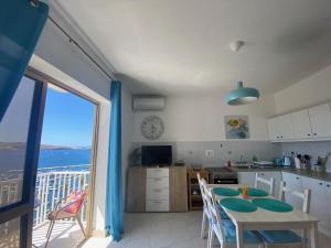 a kitchen with a table and a view of the ocean at St Paul's Bay Sunset View Apartment in St. Paul's Bay