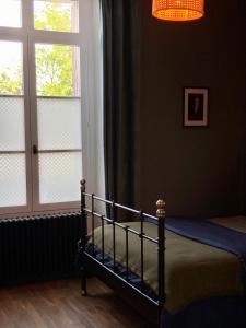 a bedroom with a bed and a window and a chandelier at Logis « Henriette » • Maison du XVe siècle in Provins