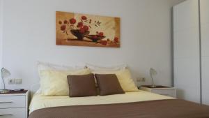 a bedroom with a bed with a painting on the wall at Apartments Jani in Hvar
