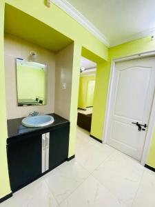烏蒂的住宿－Osprey Individual Cottage，一间带水槽、镜子和门的浴室