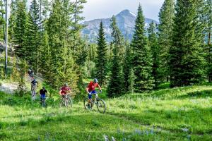 Eine Gruppe von Menschen, die auf einem Grashügel Fahrrad fahren in der Unterkunft Whitewater Inn in Big Sky