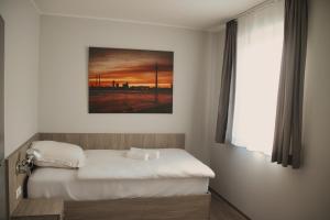 JüchenにあるLandgasthof Kelzenbergのベッドルーム1室(ベッド1台付)が備わります。壁には絵画が飾られています。