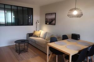 a living room with a table and a couch at Condrieu gîte climatisé parking privé in Condrieu