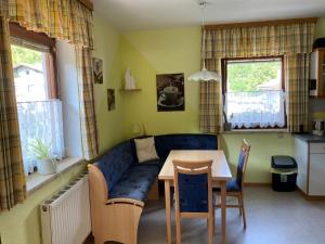 sala de estar con mesa y sofá azul en Ferienhaus Elisabeth Selbstversorger Unterkunft, en Sankt Aegyd am Neuwalde