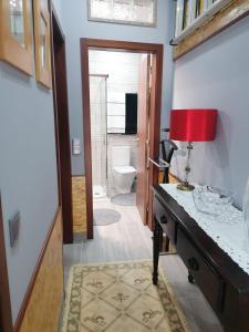 a bathroom with a desk with a red lamp on it at Casinha da Mó in Vieira do Minho