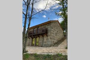 a stone house with a balcony on top of it at Formas Patuscas, Turismo Rural in Gouveia