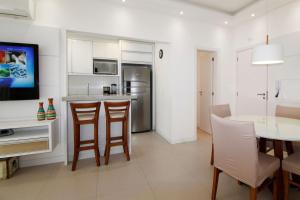 cocina y sala de estar con mesa y sillas en 1081 - Praia de Bombinhas locação de temporada, en Bombinhas