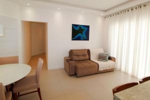 sala de estar con silla y mesa en 1081 - Praia de Bombinhas locação de temporada, en Bombinhas