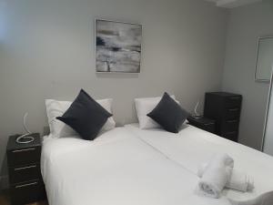 a bedroom with two beds and a teddy bear on the bed at Vetrelax Chelmsford Roseberry Apartment in Chelmsford