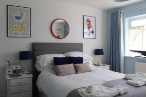 a bedroom with a large white bed with a mirror at Stylish holiday let in central Broadstairs in Broadstairs