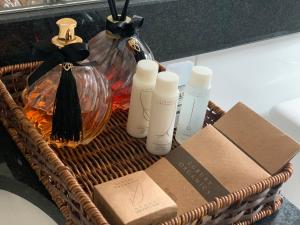 a wicker basket with a bottle of lotion and other products at Flor de Café Pousada in Pedra Menina