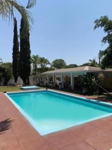 a large blue swimming pool in front of a house at Copperbelt Executive Accommodation Ndola, Zambia in Ndola