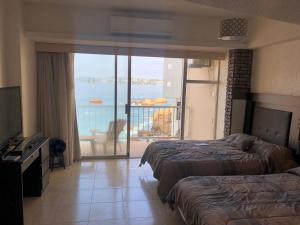 a hotel room with two beds and a balcony at SUITE EN TORRES GEMELAS a pie de playa 1403 N in Acapulco +30 photos