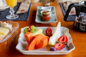 a plate of fruit and vegetables on a table at Flor de Café Pousada in Pedra Menina
