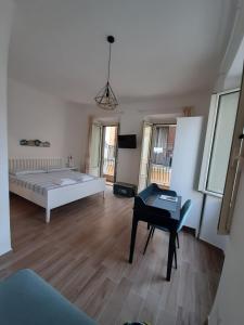 a bedroom with a bed and a table and a piano at Casetta Sapienza in Gaeta