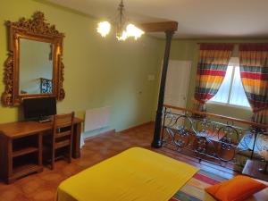 a living room with a desk and a mirror at Alojamiento Rural Los Delfines in Valdepeñas