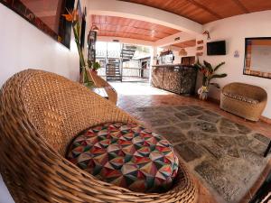 Habitación con silla de mimbre y sala de estar. en Hotel Villa Del Socorro en Socorro