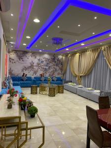 un salon avec des lumières bleues au plafond dans l'établissement قولدن ستار, à Buraydah