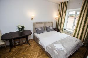 sypialnia z łóżkiem, biurkiem i oknem w obiekcie Апартаменти на площі Ринок w Lwowie
