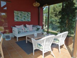 a patio with a couch and two chairs and a table at La Casa Roja Asturias in Hontoria