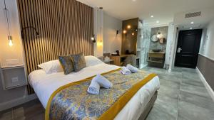 a bedroom with a large bed and a bathroom at Le Confidentiel Hôtel & SPA in Saint-Raphaël