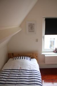 a bed in a room with a window at dreamingzeeland in Nieuwvliet