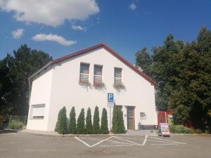 un edificio blanco con árboles delante de él en Wellness apartmán s vířivkou a saunou, en Plzeň